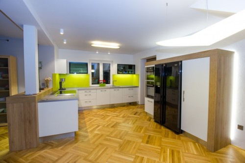 Moderní prostorná kuchyně v bílém lesku. 