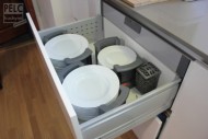 Ukládání talířů v nosičích na talíře a v zásuvce.
