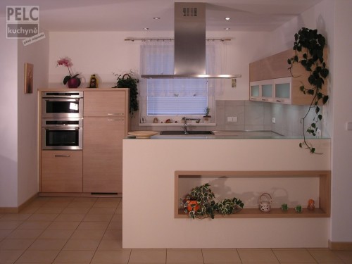 Moderní kuchyně v klasickém dekoru dřeva, která je propojena s obývacím pokojem.