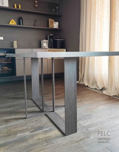 Pohled na zakázkový stůl s atypickým ocelovým podnožím v barvě stolové desky.