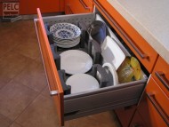 Ukládání talířů ve spodních zásuvkách s pomocí nosičů na talíře. 